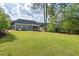 Expansive backyard featuring a lush lawn, mature trees, a screened porch, and space for recreation and relaxation at 1427 Bungalow Ave, Durham, NC 27703