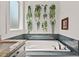 Bright bathroom features a soaking tub with decorative tiling and plant accents for a relaxing feel at 1427 Bungalow Ave, Durham, NC 27703