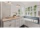Elegant bathroom featuring double sinks, a soaking tub, and stylish botanical decor at 1427 Bungalow Ave, Durham, NC 27703