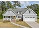 Charming home featuring a welcoming front porch, well-manicured lawn, and an attached two car garage at 1427 Bungalow Ave, Durham, NC 27703
