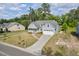 Charming two-story home with a well-manicured lawn, a paved driveway, and a welcoming front porch with a white railing at 1427 Bungalow Ave, Durham, NC 27703