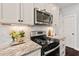 Well-lit kitchen featuring white cabinets, stainless steel appliances, and tiled backsplash at 1427 Bungalow Ave, Durham, NC 27703