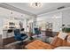Open-concept living room with a stylish leather sofa flowing to the kitchen with breakfast bar seating at 1427 Bungalow Ave, Durham, NC 27703