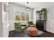 Cozy sitting area with lush green chairs, tufted ottoman, and bright window views at 1427 Bungalow Ave, Durham, NC 27703