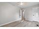 Clean bedroom with light wood floors, ceiling fan, and two doors leading to other rooms at 1513 Fairfax Rd, Durham, NC 27701