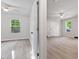 Bright bedroom featuring luxury vinyl plank flooring, a ceiling fan, and a large window at 1513 Fairfax Rd, Durham, NC 27701