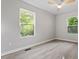 Bedroom with light wood floors, ceiling fan, two windows and neutral colored walls at 1513 Fairfax Rd, Durham, NC 27701