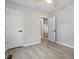 Spacious bedroom showcasing light wood floors, a ceiling fan, and a view to a hallway at 1513 Fairfax Rd, Durham, NC 27701