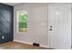 Bright entryway featuring wood-look floors, a modern accent wall, and a classic white front door at 1513 Fairfax Rd, Durham, NC 27701