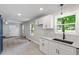 Charming kitchen showcasing white cabinets, granite counters, tile floors, and a stylish sink at 1513 Fairfax Rd, Durham, NC 27701