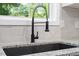Close up on kitchen sink with black fixtures and granite counters at 1513 Fairfax Rd, Durham, NC 27701