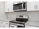 Close up of a modern kitchen with stainless steel appliances and granite countertops with gray backsplash at 1513 Fairfax Rd, Durham, NC 27701
