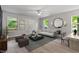 Stylish living room with a modern sofa, gray rug, accent tables and lots of light from the windows at 1513 Fairfax Rd, Durham, NC 27701