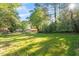 A spacious green yard with mature trees surrounding the perimeter of the property at 1513 Fairfax Rd, Durham, NC 27701