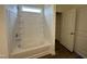 Bathroom with a tub, white tile surround and a frosted glass window at 152 Bruce Dr, Dunn, NC 28334