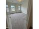 Bedroom with neutral carpet, white walls, and two windows offering neighborhood views at 152 Bruce Dr, Dunn, NC 28334