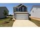 Charming two-story home with a two-car garage, and landscaped front yard against a beautiful blue sky at 152 Bruce Dr, Dunn, NC 28334
