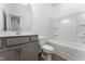 Bathroom showcasing a gray vanity, quartz countertop, toilet, and white tub at 152 Bruce Drive Dr, Dunn, NC 28334