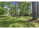 Spacious backyard featuring mature trees and a well-maintained lawn, offering a serene outdoor setting at 1532 Cone Ave, Apex, NC 27502