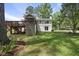 Lush backyard featuring a deck, manicured lawn, and partial view of the home's exterior at 1532 Cone Ave, Apex, NC 27502