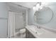 Bathroom featuring tile, a shower, toilet, granite countertop, blue walls, and a round mirror at 1532 Cone Ave, Apex, NC 27502