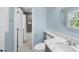 Bathroom featuring a shower, toilet, marble countertop, blue walls, and a round mirror at 1532 Cone Ave, Apex, NC 27502