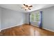 Bright bedroom with hardwood floors, ceiling fan, and large window with natural light at 1532 Cone Ave, Apex, NC 27502