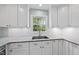 A kitchen countertop features granite surfaces, white cabinets, and stainless steel sink, blending style with functionality at 1532 Cone Ave, Apex, NC 27502