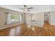 An open-concept living area with hardwood floors, large window, ceiling fan, and an abundance of natural light at 1532 Cone Ave, Apex, NC 27502