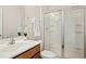 Bathroom features shower with glass doors, wood cabinets, and a white sink at 1557 Tice Hurst Ln, Apex, NC 27502