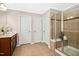Bathroom featuring tiled floors, tiled shower with glass doors, and wood cabinets at 1557 Tice Hurst Ln, Apex, NC 27502