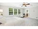 Bedroom featuring large windows, carpet, tray ceiling, and a ceiling fan at 1557 Tice Hurst Ln, Apex, NC 27502