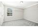 This is a simply decorated bedroom with an open closet and a large, sunny window at 1557 Tice Hurst Ln, Apex, NC 27502