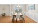 Bright and airy dining area featuring a contemporary chandelier, wainscoting, and a large window for natural light at 1557 Tice Hurst Ln, Apex, NC 27502