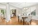An elegant dining room with a stone fireplace and views into an open-concept living space with a modern chandelier at 1557 Tice Hurst Ln, Apex, NC 27502