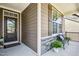 Cozy front porch with stone accents, adorned with seating and greenery for a welcoming entrance to the home at 1557 Tice Hurst Ln, Apex, NC 27502