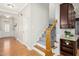 Open hallway showcases hardwood floors, an elegant staircase, and access to a modern kitchen and front entry at 1557 Tice Hurst Ln, Apex, NC 27502