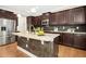Gourmet kitchen boasts granite countertops, stainless steel appliances, a large island, and dark wood cabinets at 1557 Tice Hurst Ln, Apex, NC 27502