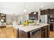 Open concept kitchen features granite countertops, stainless steel appliances, and view into the living room at 1557 Tice Hurst Ln, Apex, NC 27502
