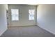 Bright bedroom with plush neutral carpet and two large windows providing plenty of natural light at 1565 Wendell Valley Blvd, Wendell, NC 27591
