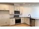 Bright, modern kitchen with stainless steel appliances, granite countertops, white cabinetry, and wood-look flooring at 1565 Wendell Valley Blvd, Wendell, NC 27591