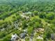 Aerial view of a neighborhood featuring lush trees, a tennis court and mature landscaping at 1603 Hermitage Ct, Durham, NC 27707