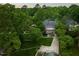 Scenic aerial view of a home nestled among lush trees, showcasing its expansive yard and driveway at 1603 Hermitage Ct, Durham, NC 27707
