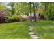 Landscaped backyard features a lush lawn, a stone path, a greenhouse and a chicken coop at 1603 Hermitage Ct, Durham, NC 27707