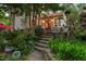 Inviting backyard patio with stone steps, lush greenery, and cozy outdoor seating under string lights at 1603 Hermitage Ct, Durham, NC 27707