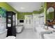 Bathroom with a claw foot tub, a glass shower, a brick accent wall, and green painted walls at 1603 Hermitage Ct, Durham, NC 27707