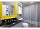 Bathroom featuring a black marble sink, yellow frame mirror, and gray shower curtain at 1603 Hermitage Ct, Durham, NC 27707