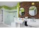 Bathroom featuring a brick wall, modern shower with glass door, and double vanity at 1603 Hermitage Ct, Durham, NC 27707