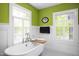 Charming bathroom featuring a clawfoot tub, wainscoting, and lots of natural light from large windows at 1603 Hermitage Ct, Durham, NC 27707