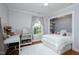Sunlit bedroom featuring hardwood floors, a desk area, and a closet with built-in shelving at 1603 Hermitage Ct, Durham, NC 27707